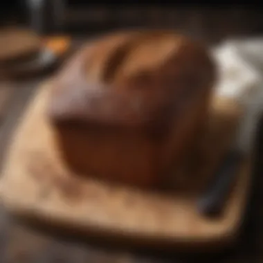 A rustic loaf of freshly baked pumpernickel bread on a wooden cutting board