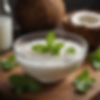 Coconut Oil in a Glass Bowl Coconut oil in a glass bowl with wooden utensils and a sprig of mint